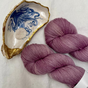 purple yarn next to an octopus decal on an oyster shell